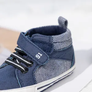 Close-up of navy blue baby high-top walker shoes with hook-and-loop strap and 91 print