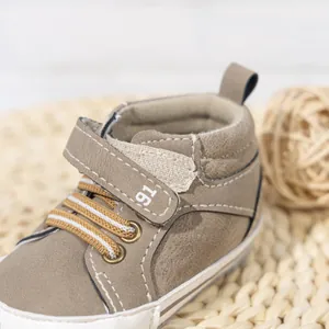 Detail of high-top baby shoes with velcro strap and textured synthetic leather