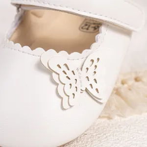 Détail de chaussure bébé princesse avec papillon et bords festonnés pour les 6-12 mois