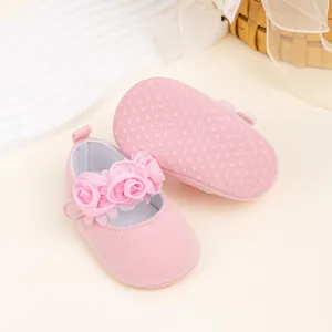 Detalle de zapatos rosas para bebé con flores de tela y suela de tela antideslizante