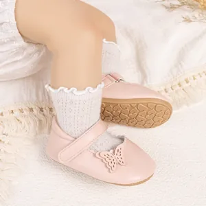 Vue détaillée des chaussures bébé roses avec papillons et semelles en caoutchouc souple
