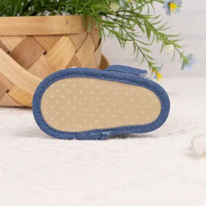Détail de la semelle souple antidérapante pour bébé avec picots et bordure denim