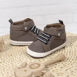 Detail of baby high-top walking shoe with brown texture, velcro strap and non-slip sole