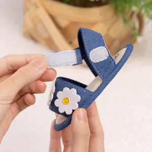 Détail de la fermeture Velcro réglable sur les sandales en jean bleu pour bébé
