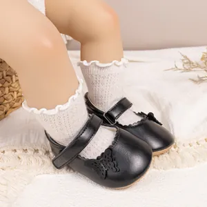 Détail de chaussures Mary Jane bébé avec décor papillon et chaussettes en dentelle douce
