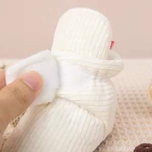 Détail de chaussures bébé souples avec fermeture velcro et texture velours blanc