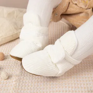 Détail de chaussures de marche pour bébé en velours côtelé blanc avec volants