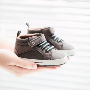 Detail of baby walking shoes with hook-and-loop closure and soft non-slip white soles