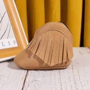 Détails de bottes de cowboy pour bébé en similicuir marron à franges sur bois blanc