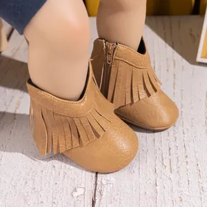 Détail macro de bottes de cowboy pour bébé avec longues franges et fermeture éclair