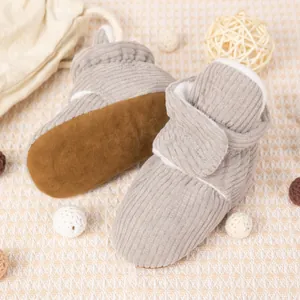 Gros plan sur des bottines bébé en velours côtelé gris clair avec doublure polaire