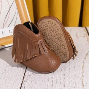 Vue détaillée de bottes de cowboy marron pour bébé avec franges et semelles antidérapantes