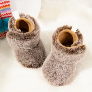 Plush brown baby winter boots with easy-on heel pull tab on white fluffy carpet