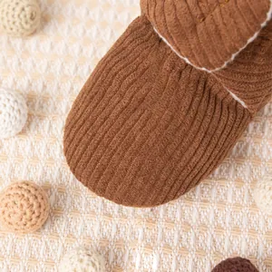 Détail de chaussure pour bébé en velours côtelé marron avec doublure polaire