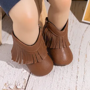 Gros plan de bottines bébé à franges marron avec zip et texture en similicuir PU