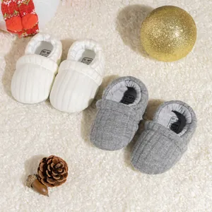 Detail view of knitted baby walking shoes with soft lining and size labels for 0-6 months