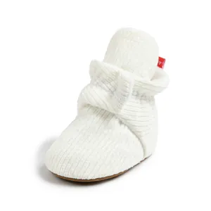 Vue détaillée de la texture du tissu blanc côtelé et semelle souple pour bébé