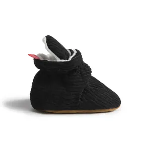Détail de chaussure bébé montrant la texture velours noir et la doublure polaire