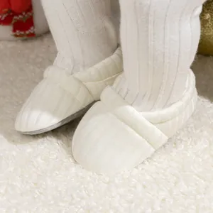 Close-up of baby knit booties featuring ribbed texture and anti-slip beaded soles