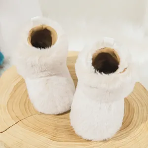 Macro detail of plush warm baby winter boots with fluffy texture on a wooden stand