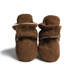 Détail de chaussures de marche pour bébé en velours côtelé marron et doublure peluche