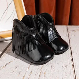 Nahaufnahme schwarzer Baby-Fransenstiefel mit Reißverschluss und glänzendem Finish