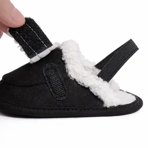Detail of adjustable velcro strap and soft lamb wool lining on black baby winter shoes