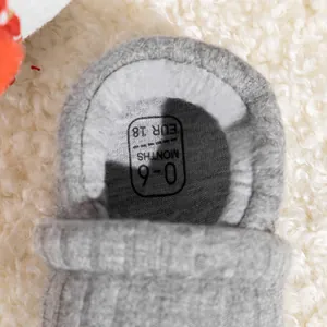 Detailed top view of grey knitted baby shoes showing printed size 18 and soft cotton texture