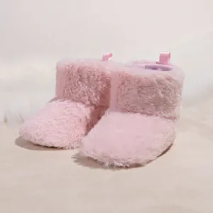 Close-up of pink plush baby boots featuring a soft faux fur exterior and back pull tabs