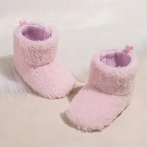 Detail of plush baby winter boots in light pink with soft purple fabric lining