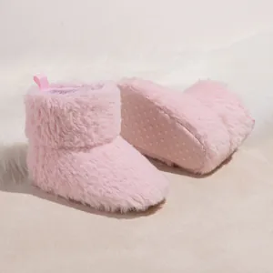 Close-up of pink baby boots showing soft plush texture and anti-slip dotted soles