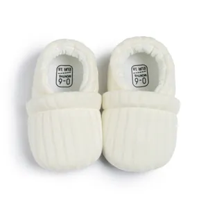 Detail view of knitted baby shoes showing 0-6 months size marking and ribbed texture