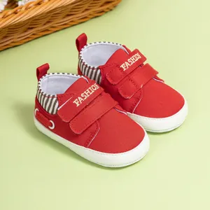 Vue détaillée de chaussures bébé en toile rouge avec double scratch et détail mode