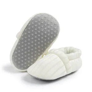 Detail of soft knit baby shoes featuring grey anti-slip silicone dots on flexible soles