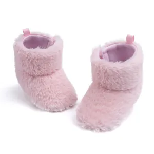 Close-up of pink plush baby boots with soft purple lining and convenient pull tab