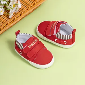 Détail de chaussures en toile rouge pour bébé avec double velcro et semelles souples antidérapantes