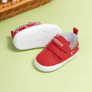 Détail de chaussures bébé rouges montrant la semelle antidérapante et le velcro
