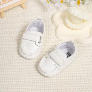 Detail shot of white synthetic leather baby shoes with hook-and-loop closure