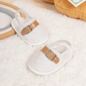 Close-up of baby winter shoes with white fleece, brown leather strap and elastic heel