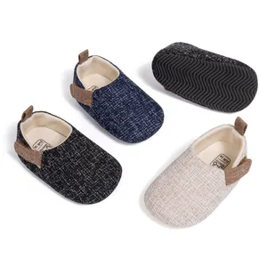 Detail showing non-slip wave rubber soles and woven fabric texture of baby shoes