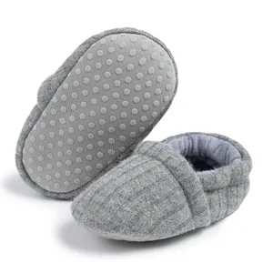 Detailed view of grey baby knitted shoes with anti-slip silicone dots on soft soles