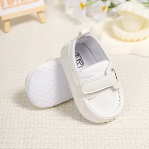 Detail of white baby walking shoes showing anti-slip sole and hook-and-loop closure