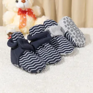 Detailansicht der rutschfesten Gummipunkte und des Baby-Logos auf marineblauen Socken