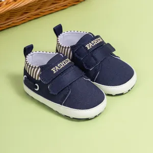 Gros plan détaillé de chaussures pour bébé en toile bleu marine avec logo doré