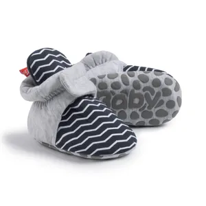 Nahaufnahme der Baby-Socken-Schuhe mit blauen Streifen und rutschfester Gummisohle