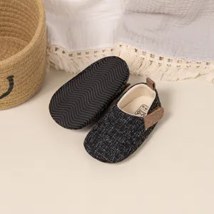 Close-up of baby walking shoes showing anti-slip wavy textured soles and soft fabric