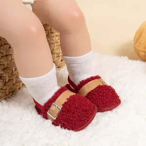 Detail of red faux shearling baby walking shoe with metal buckle and elastic strap