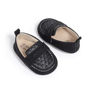 Macro shot of black baby loafers with woven texture and size label 0-6 months