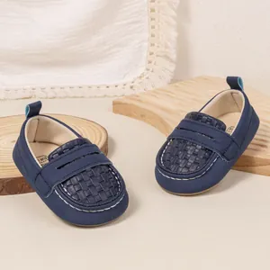 Detail of navy blue baby loafer with woven toe design and durable white hand-stitching