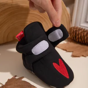 Details von Babyschuhen mit rotem Herz-Stickerei und doppeltem Klettverschluss